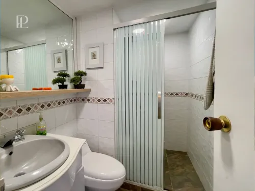 Ba&ntilde;o social moderno con acabados elegantes y ventilaci&oacute;n natural